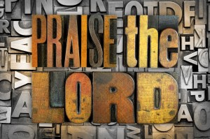 The words PRAISE THE LORD written in vintage letterpress type